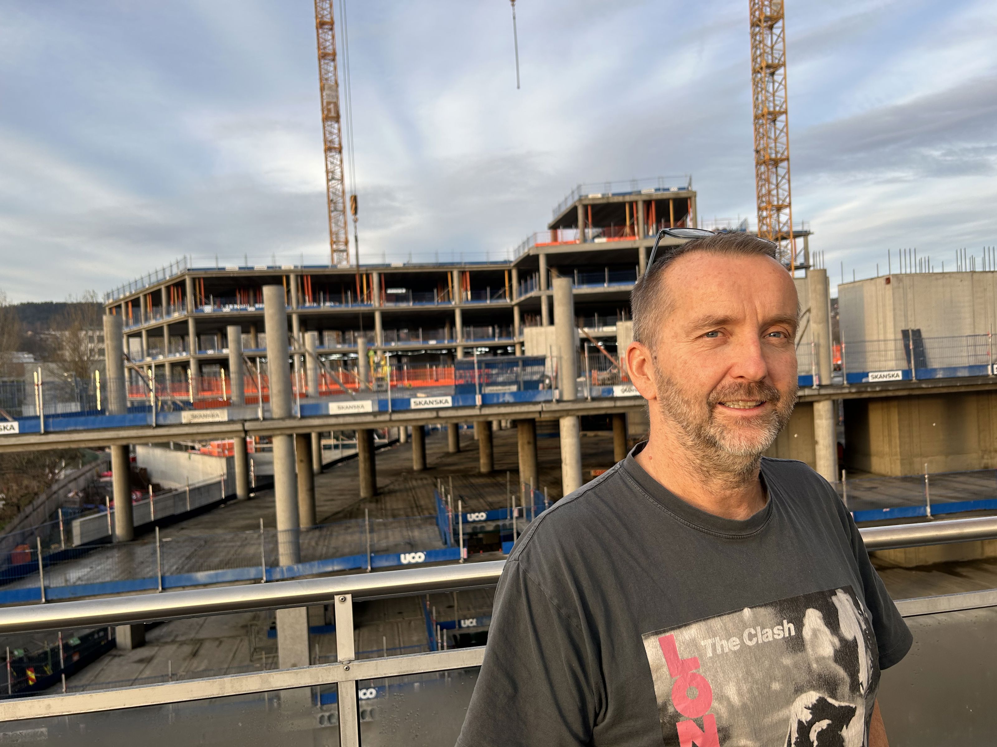 A man stands in front of a building project.